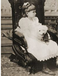 Helen Keller enfant assise avec son chien sur les genoux