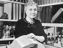 Helen Keller lit le braille une fleur à la main